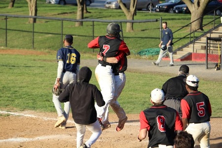 Thirus Jones (7) is quick to embrace Mike Mowery (center) after the latter scores the winning run. Photo by Joey Gallo